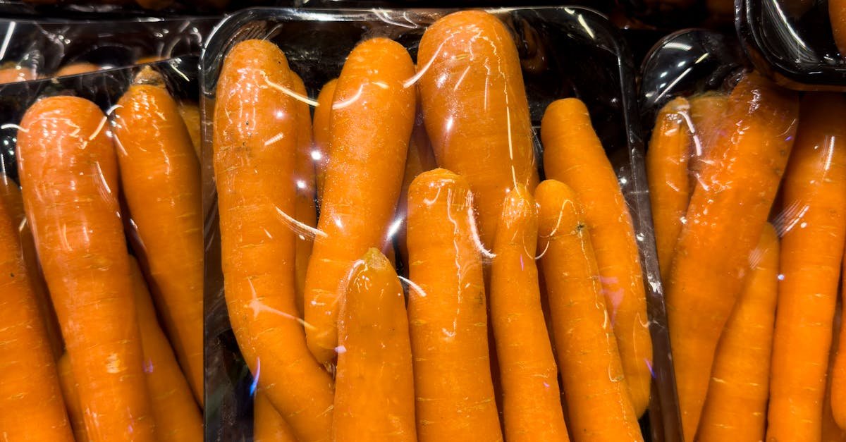 High-quality fresh carrots packed in plastic trays at a grocery store display.